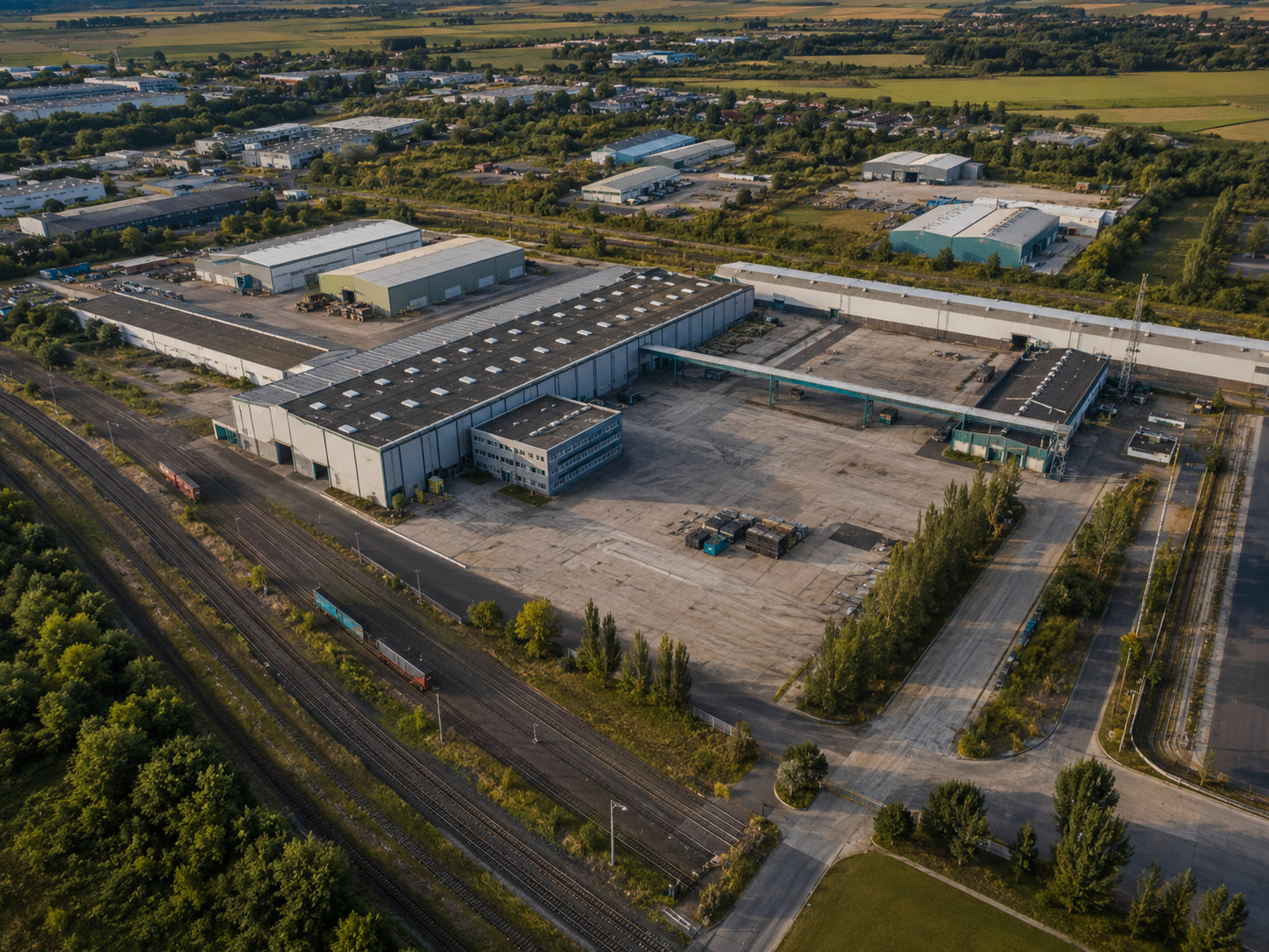 Neutralna wizualizacja rozległej nieruchomości przemysłowej z infrastrukturą kolejową